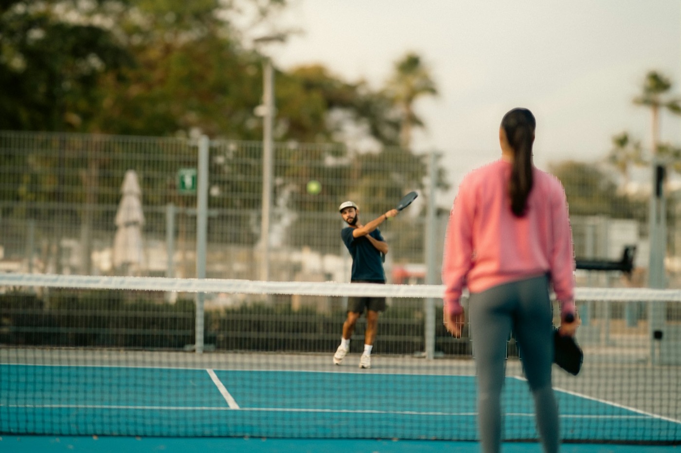 Two people playing a racquet sport on a court
